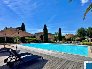 a chair and an umbrella next to a swimming pool at villa Clémentine - 3 chambres in Lecci