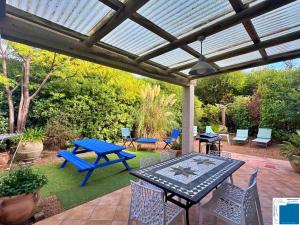 a patio with a blue picnic table and chairs at villa Clémentine - 3 chambres in Lecci