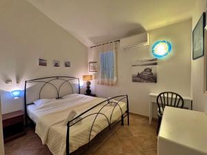 a bedroom with a bed and a desk and a table at villa Clémentine - 3 chambres in Lecci