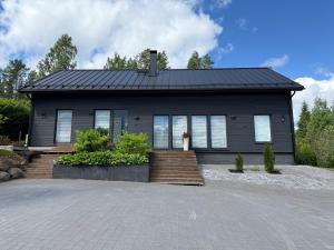 a house with a black roof at Villa Ensola with pool in Savonlinna