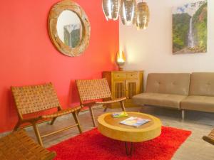 a living room with a couch and chairs and a table at Appartement spacieux avec jardin et piscine à Lamentin, 97 m² in Lamentin