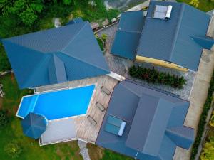 an overhead view of a house with a swimming pool and a blue roof at Appartement spacieux avec jardin et piscine à Lamentin, 97 m² in Lamentin +4 photos