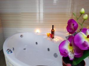 a bathroom with a bath tub with candles and purple flowers at Nature Love in Casas del Abad