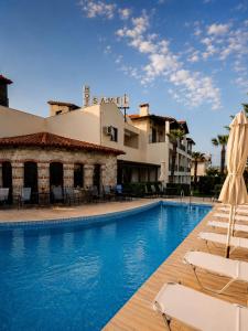 a swimming pool with lounge chairs and a hotel at Samel Hotel in Siviri