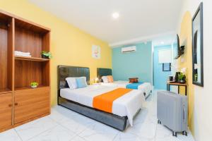 a bedroom with two beds in a room at Sans Hotel Sedana Batam in Nagoya