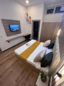 a bedroom with a large bed with a tv on the wall at Hotel PRM Sweet Stay in Bhundsi +25 photos