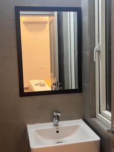 a bathroom sink with a large mirror above it at Hotel PRM Sweet Stay in Bhundsi