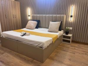 a bedroom with a large bed with a phone on it at Hotel PRM Sweet Stay in Bhundsi