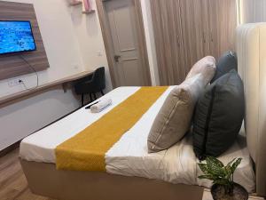 a hotel room with a bed with pillows and a television at Hotel PRM Sweet Stay in Bhundsi