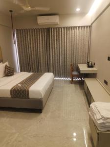 a hotel room with a bed and a desk at Umbrellaa Hotels in Ahmedabad