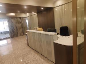 an office with a desk and chairs in a room at Umbrellaa Hotels in Ahmedabad