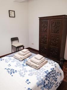 a bedroom with a bed with a dresser and a chair at Apartment with Mountain View in Eiriz – 65 sqm – Terrace in Eiriz +12 photos