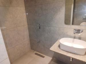 a bathroom with a sink and a shower at Umbrellaa Hotels in Ahmedabad