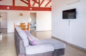 a living room with a couch and a tv at Maison vue sur mer à Vieux-Habitants + Terrasse in Vieux-Habitants