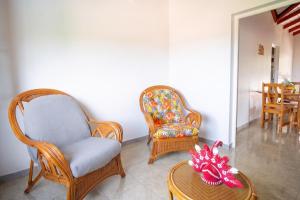 a living room with two chairs and a table at Maison vue sur mer à Vieux-Habitants + Terrasse in Vieux-Habitants +28 photos