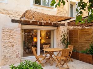 a patio with a table and chairs in front of a house at Maison à Vedène avec piscine privée in Vedène