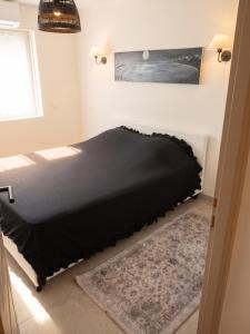 a bed in a bedroom with a black bedspread at Maison à Vedène avec piscine privée in Vedène