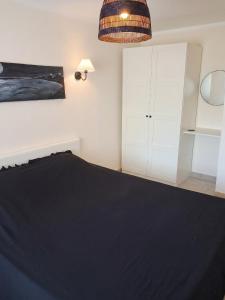 a bedroom with a black bed and white cabinets at Maison à Vedène avec piscine privée in Vedène +4 photos