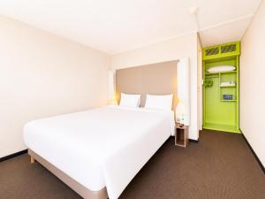 a bedroom with a large white bed and green accents at Campanile Troyes Sud - Buchères in Troyes