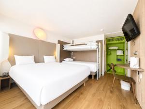 a hotel room with a large bed and a tv at Campanile Troyes Sud - Buchères in Troyes