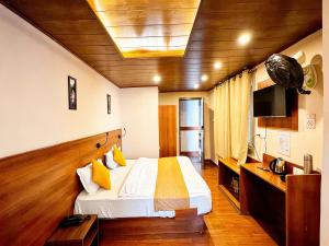 a hotel room with a bed and a television at Hotel Ambrosia in Gangtok