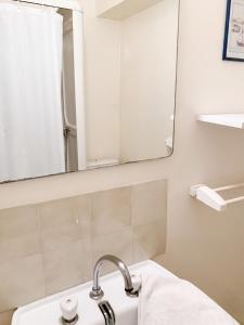 a bathroom with a sink and a mirror at Appartement cosy à Néris-les-Bains, 20 m², balcon avec vue in Néris-les-Bains