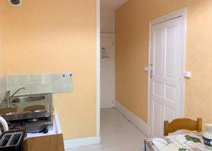 a kitchen with a sink and a counter with a door at Appartement cosy à Néris-les-Bains, 20 m², balcon avec vue in Néris-les-Bains