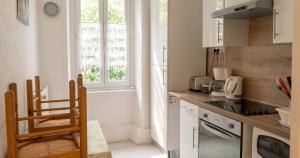 a kitchen with white cabinets and a sink and a window at Appartement cosy à Néris-les-Bains, 20 m², balcon avec vue in Néris-les-Bains +3 photos