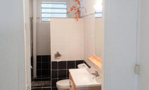 a bathroom with a white toilet and a sink at Appartement spacieux au Vauclin avec piscine privée in Le Vauclin