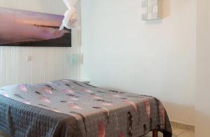 a bed with a quilt on it in a room at Appartement spacieux au Vauclin avec piscine privée in Le Vauclin