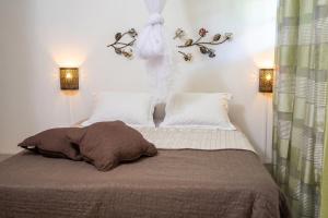 a bedroom with a bed with two lights and two pillows at Appartement spacieux au Vauclin avec piscine privée in Le Vauclin