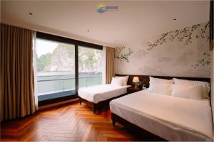 a hotel room with two beds and a large window at Sunshine Golden Cruises in Cat Ba