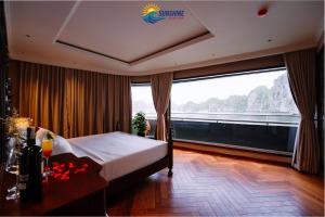 a hotel room with a bed and a large window at Sunshine Golden Cruises in Cat Ba
