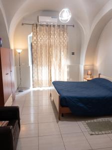 a bedroom with a blue bed and a window at Modern Studio in Catania with Air Conditioning in Catania