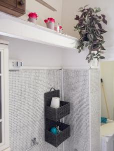 a bathroom with two baskets on the wall and a plant at Modern Studio in Catania with Air Conditioning in Catania +15 photos
