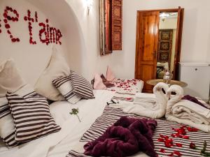 two swans are sitting on a bed in a room at Exceptional Villa in Marrakech with Private Pool in Marrakesh