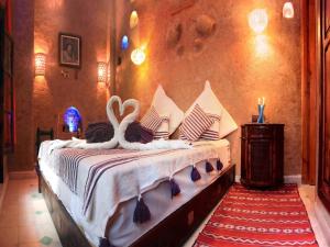 a bedroom with a bed with two swans on it at Exceptional Villa in Marrakech with Private Pool in Marrakesh