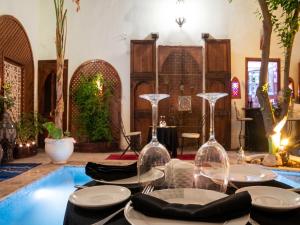 a table with wine glasses and a swimming pool at Exceptional Villa in Marrakech with Private Pool in Marrakesh +19 photos