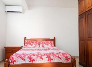 a bedroom with a bed with a red and white bedspread at Appartement charmant au Lamentin avec terrasse et jardin, 46 m² in Le Lamentin