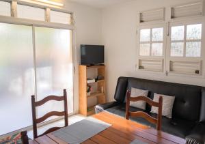 a living room with a couch and a tv at Appartement charmant au Lamentin avec terrasse et jardin, 46 m² in Le Lamentin