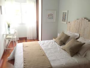 a bedroom with a large bed with white sheets and pillows at Apartamento Playa Poniente in Gijón