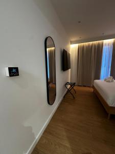 ein Schlafzimmer mit einem Bett und einem Spiegel an der Wand in der Unterkunft Aetheria resort in Samothráki