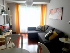 a living room with a couch and a table at Apartamento Playa Poniente in Gijón