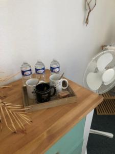 a tray with cups and water bottles on a table at Chambre la paix verte in Payrac