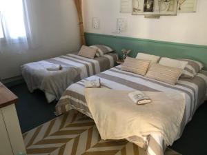 two beds in a room with towels on them at Chambre la paix verte in Payrac