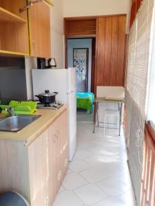 a kitchen with a refrigerator and a table at Studio charmant à Sainte-Anne, 23 m², piscine partagée in Sainte-Anne