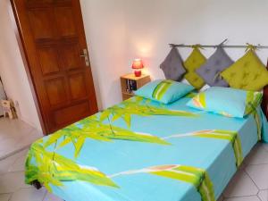 a bedroom with a large bed with blue sheets at Studio charmant à Sainte-Anne, 23 m², piscine partagée in Sainte-Anne