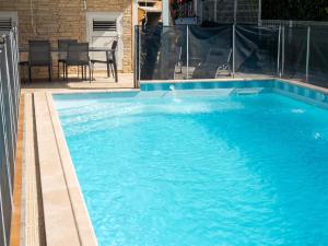 a large swimming pool with blue water at Studio charmant à Sainte-Anne, 23 m², piscine partagée in Sainte-Anne
