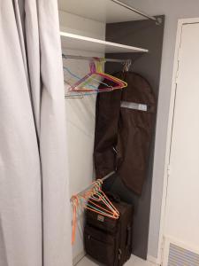 a suitcase and a bag in a closet with a curtain at Studio romantique à Saint-François - 25 m² avec piscine in Saint-François