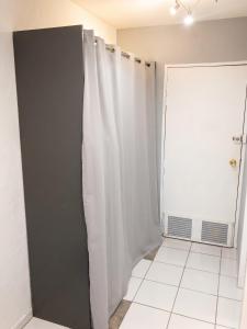 a bathroom with a shower curtain next to a door at Studio romantique à Saint-François - 25 m² avec piscine in Saint-François